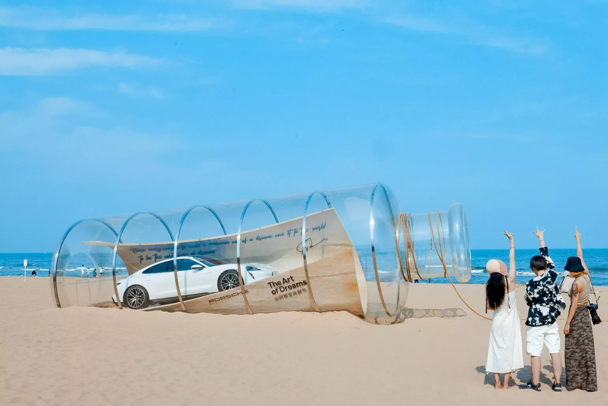 ポルシェが中国にて大規模アート作品を展示！砂浜には「ボトルに入ったメッセージ風」のタイカン他、夢をテーマにした展示がなされる
