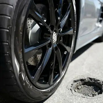 ポルシェ718ケイマンのタイヤ / ホイールと道路上に空いた穴（AI生成）