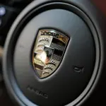 ポルシェ マカン エレクトリックのインテリア（ステアリングホイールのセンターとエンブレム）