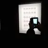 バンクシー展にて、展示物を撮影する様子