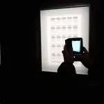バンクシー展にて、展示物を撮影する様子