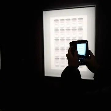 バンクシー展にて、展示物を撮影する様子