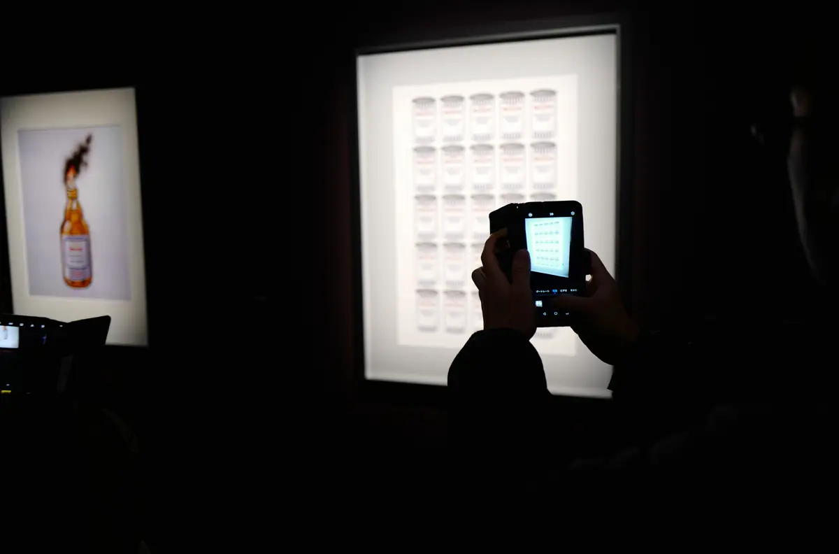 バンクシー展にて、展示物を撮影する様子