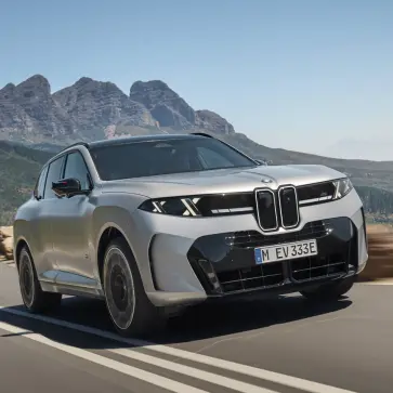 新型BMW X5(シルバー)の全景(フロント、走行)